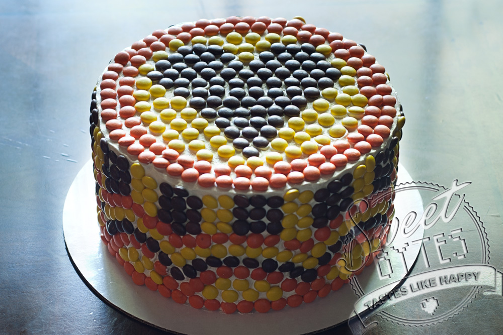 A Reese's Pieces Mosaic birthday cake with a heart on top,