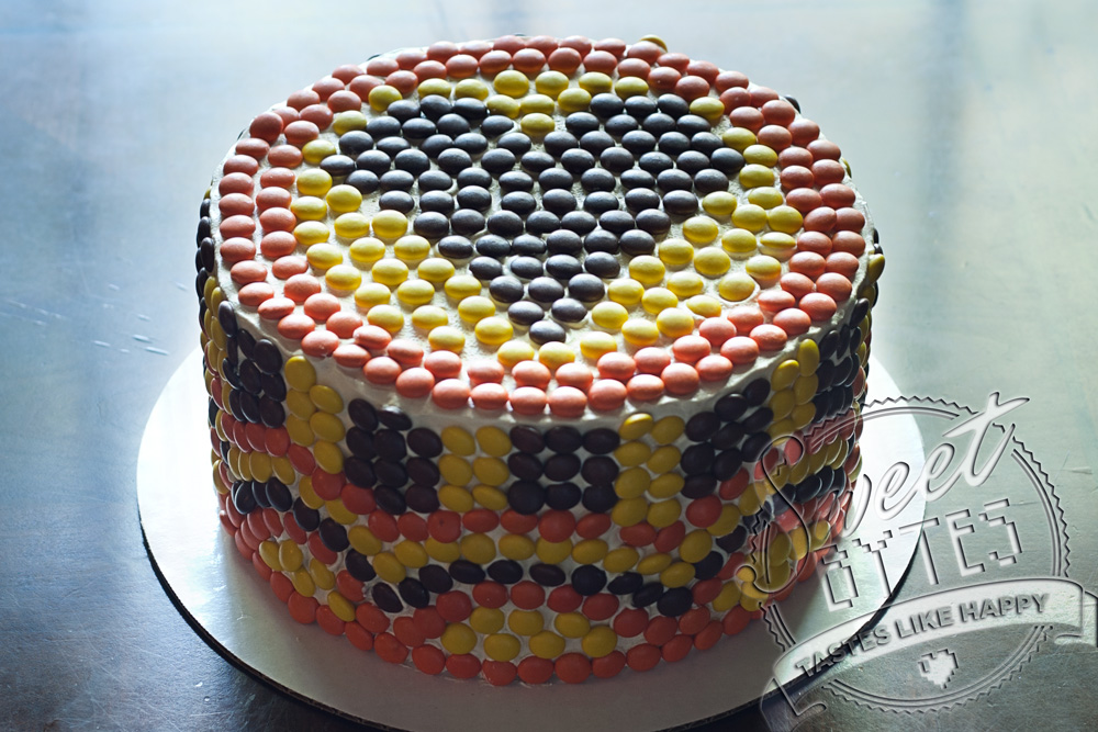 A Reese's Pieces Mosaic birthday cake with a heart on top,