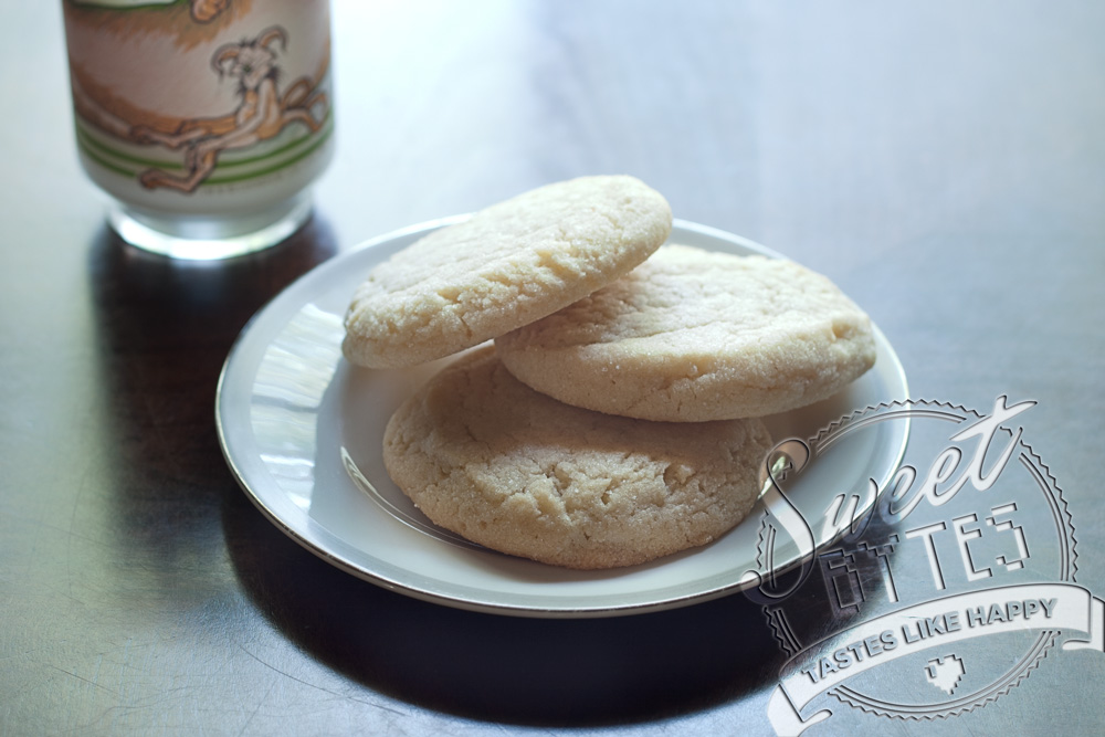 3 perfectly baked sugar cookies on a white dessert plate to show how baking cookies is a rewarding past time!