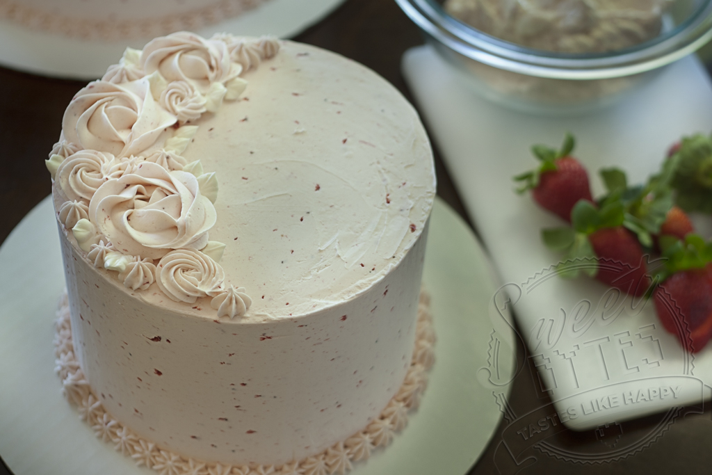 Close up view of strawberry layer cake with strawberry buttercream piped decorations on top