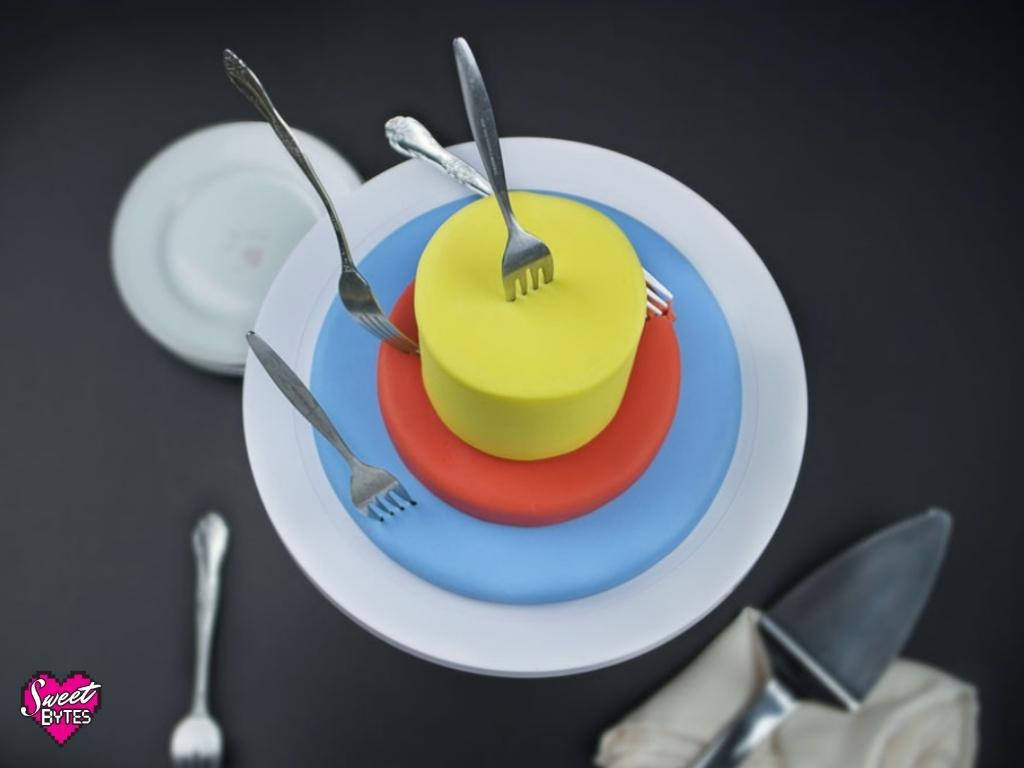 a target cake with forks sticking out of it like arrows would a target representing a bakery target market