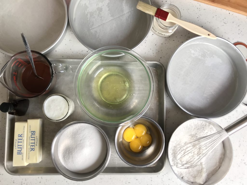 learning how to read a recipe using mise-en-place, all ingredients to prepare a German Chocolate cake are pre-measured in bowls and arranged on a baking sheet. 