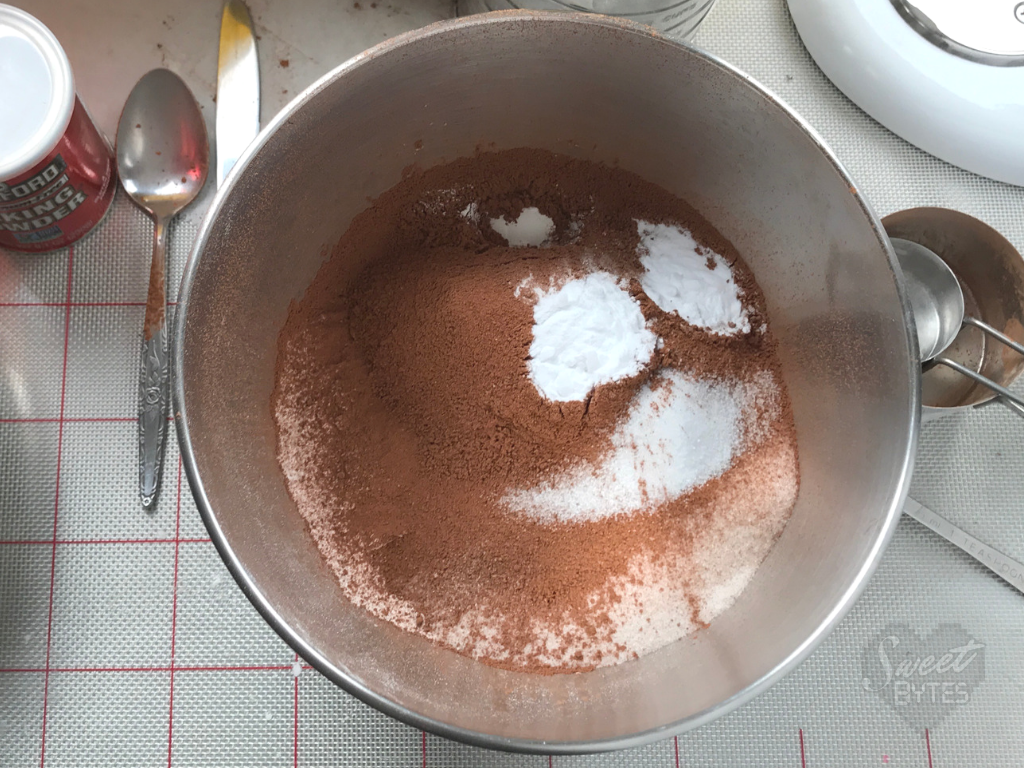 Large stainless steel mixing bowl with dry ingredients for the chocolate cake recipe inside