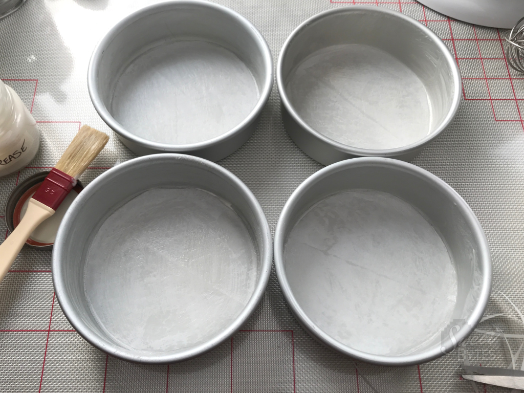 4 six inch, greased cake pans ready to make chocolate cake 