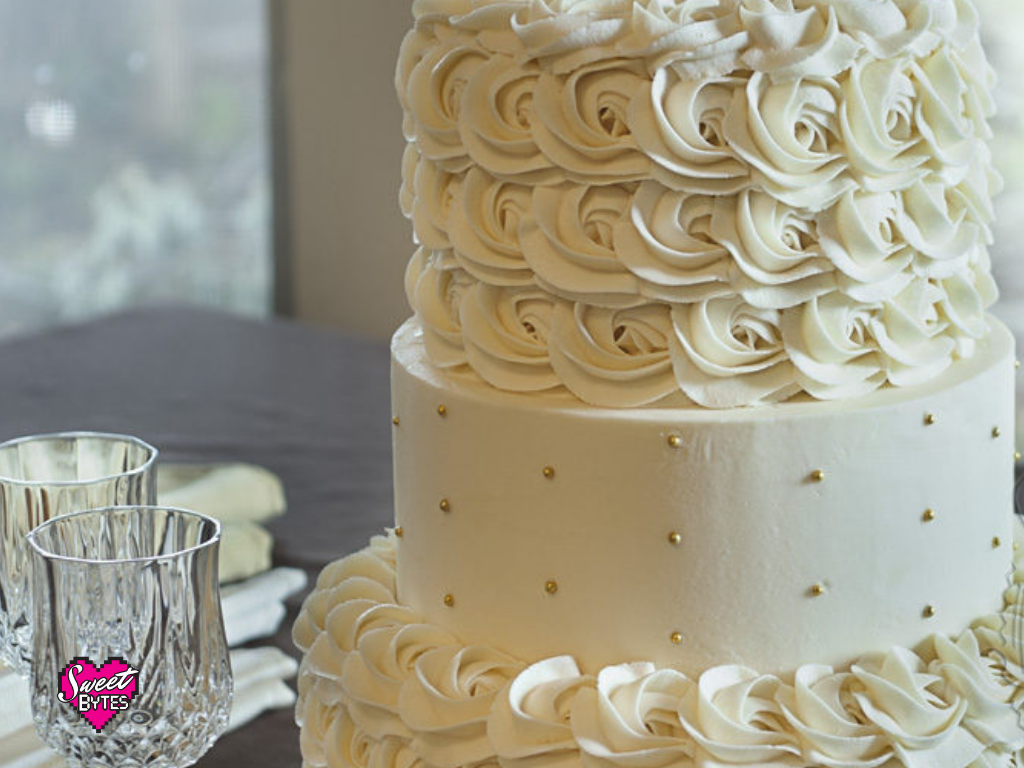 Close up of a 3 tiered cake with vanilla buttercream