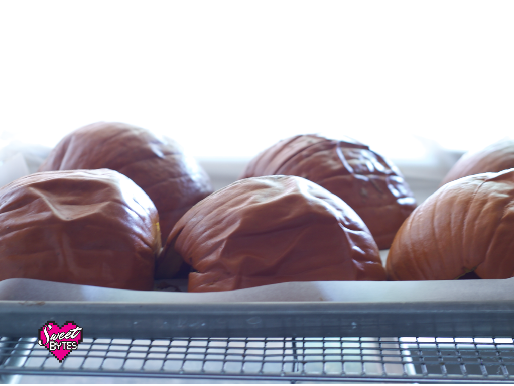 Baked pumpkins on a baking sheet cooling to cook pumpkin for pie