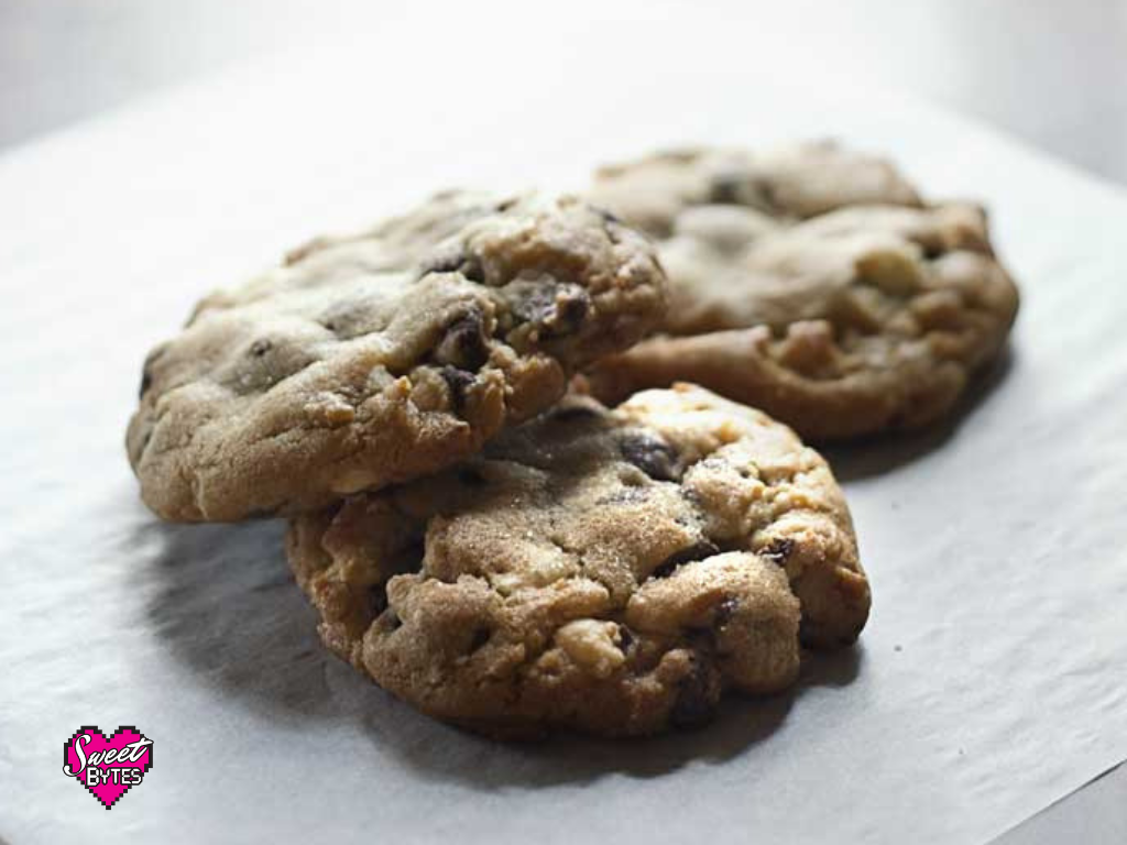 3 big triple chocolate chunk cookie arranged on a white parchment paper after baking cookies