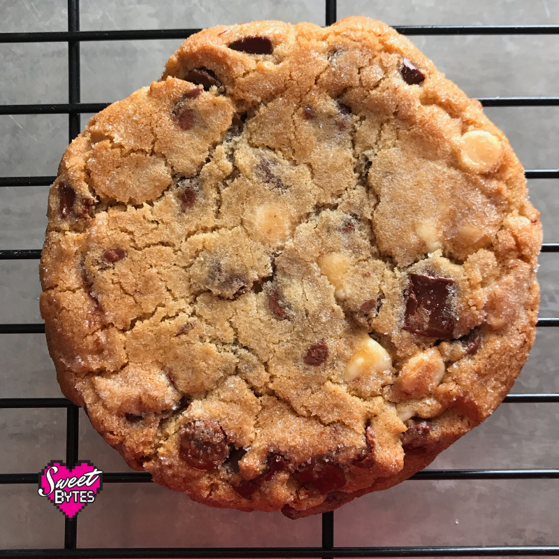 A close up view of a large triple chocolate chunk cookie
