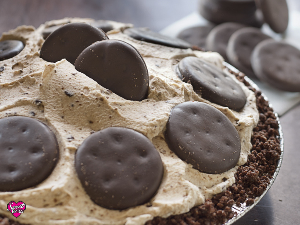 Thin Mint pie with whipped cream and Thin Mints Girl Scout Cookies in the background