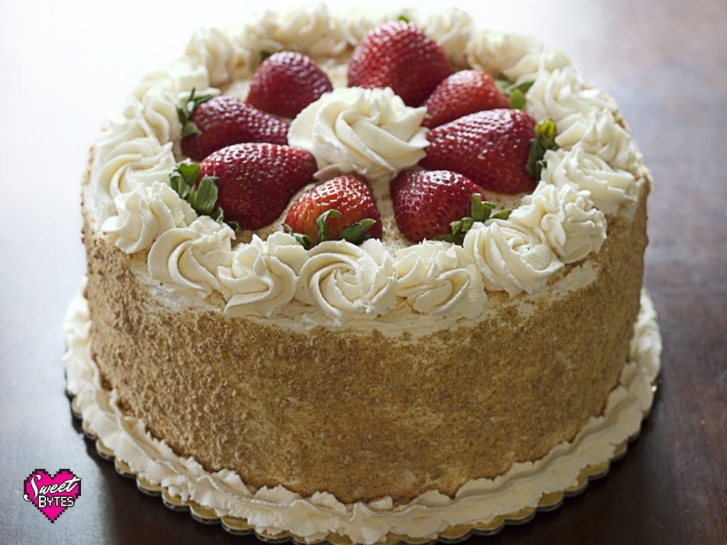 A fully decorated strawberry and cream cake sitting on a table