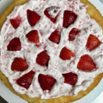 Inside view of strawberry and cream layer cake. Cake layer with strawberry and cream and quartered strawberries.