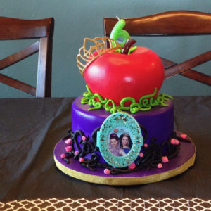 Two tier cake with carved apple on top and Disney Descendants decorations