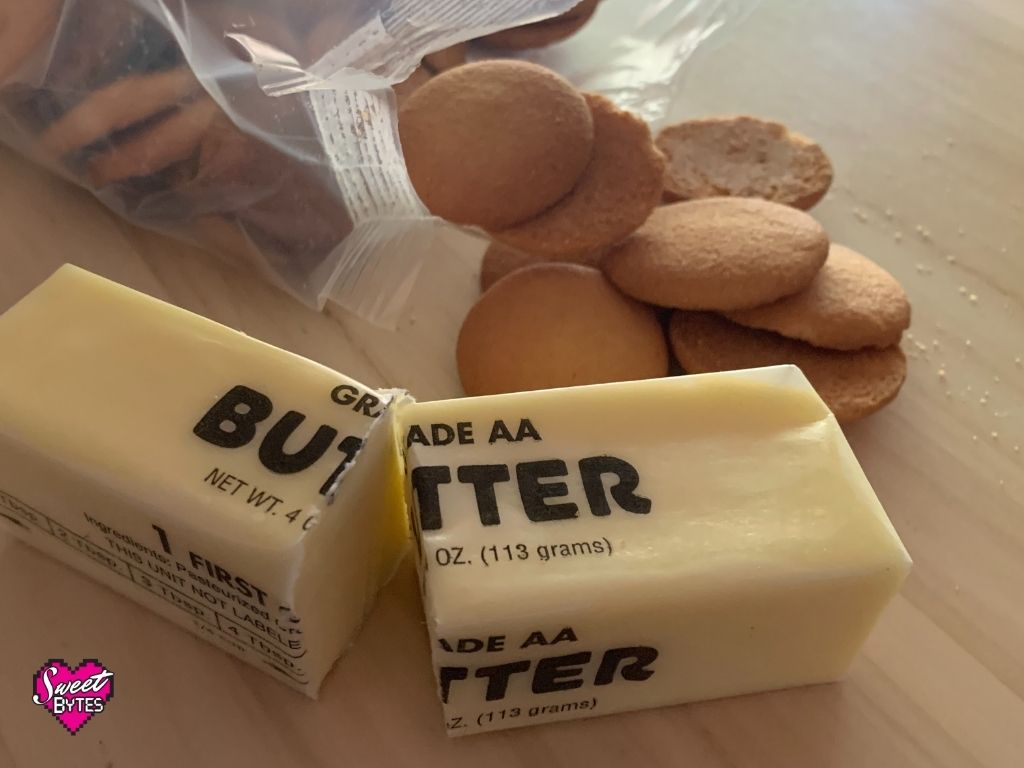 Butter and vanilla wafers on a wooden cutting board used to make vanilla wafer pie crust